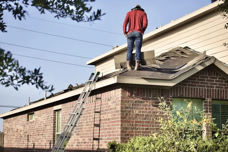 Professional roofer working on a residential roof in Halladay Corner
